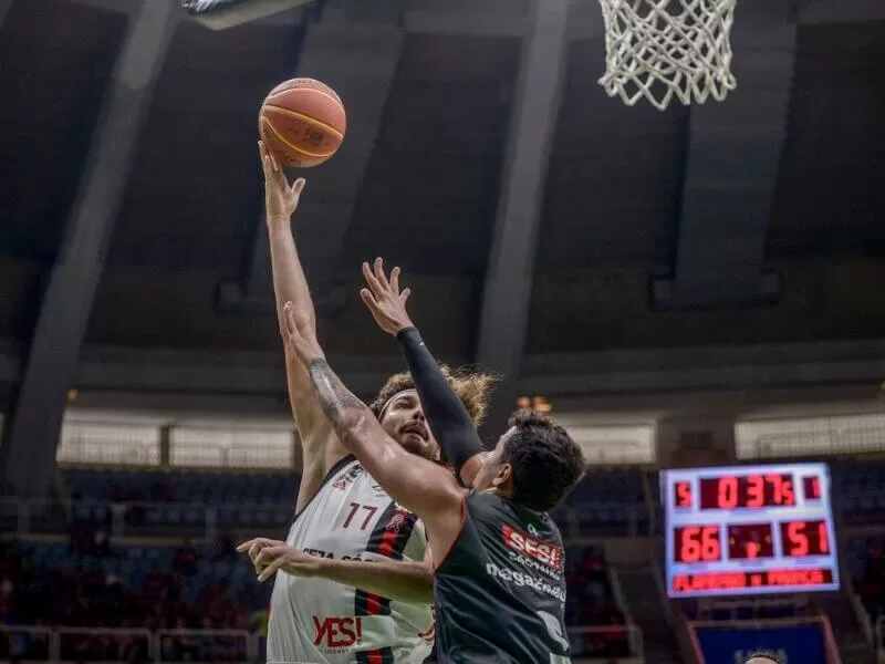 imagem de dois jogadores brasileiros de basquetebol pulando para a cesta