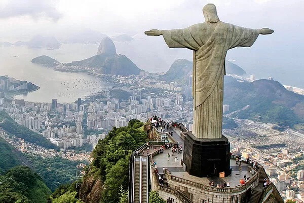 imagem de uma vista aerea por tras da estatua do Cristo Redentor pegando a baia da cidade do Rio de Janeiro