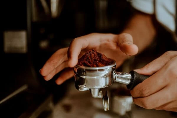 imagem de um barista preparando café em uma máquina de café